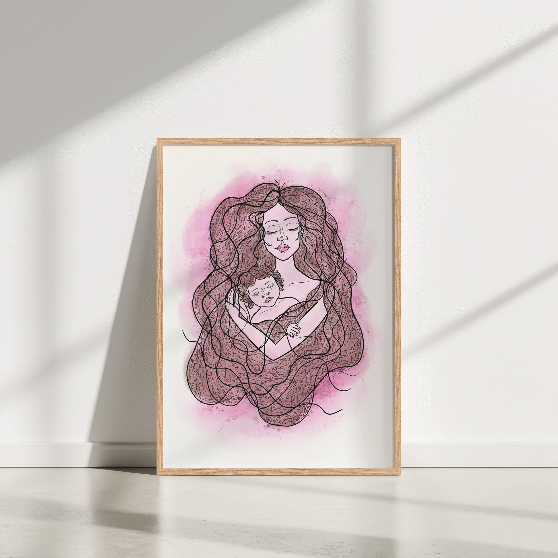 Framed artwork of a woman holding a child with a pink watercolor background on a white wall.