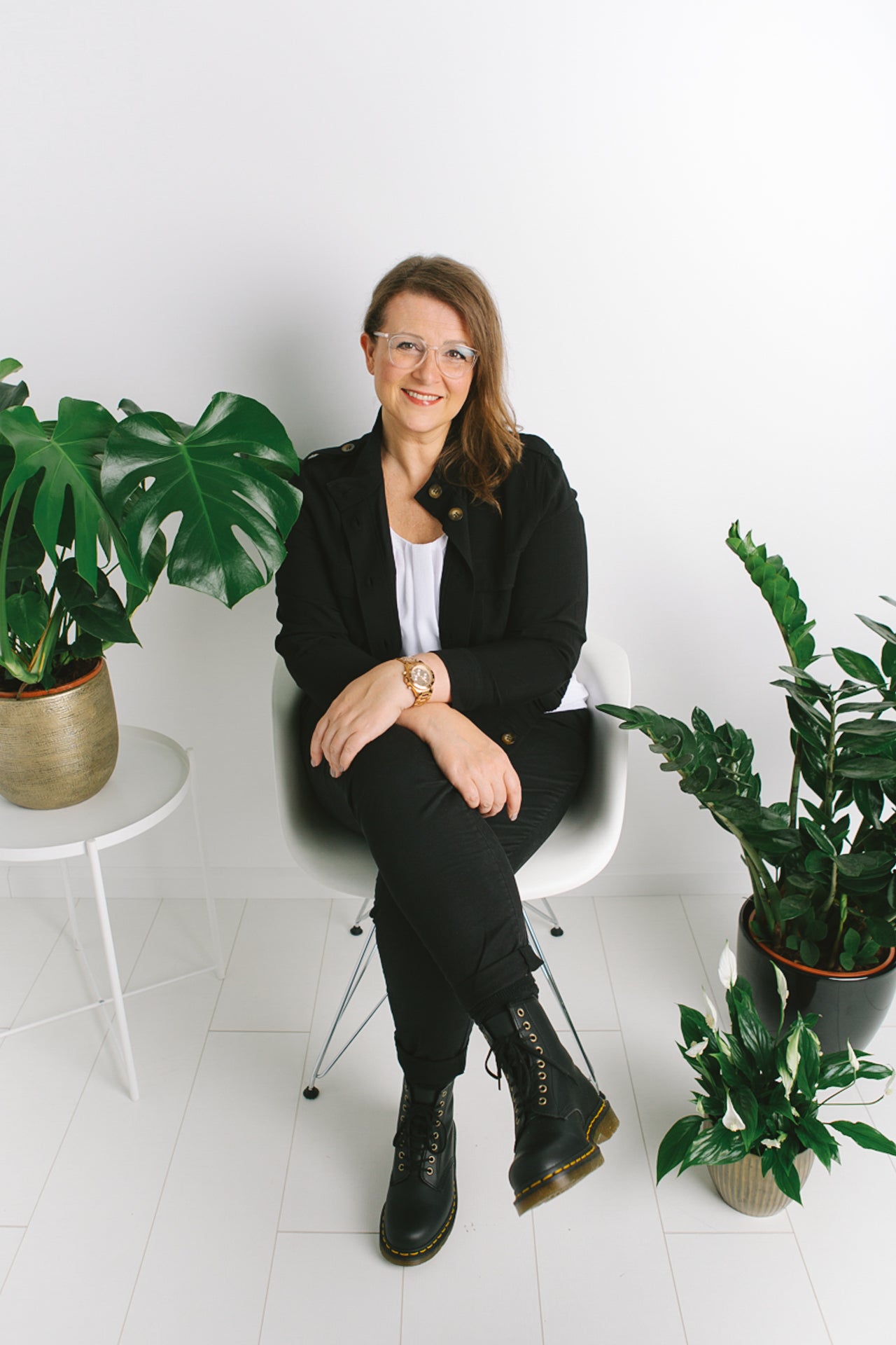 Yvonne Dutch Artist sitting in a white chair surrounded by plants